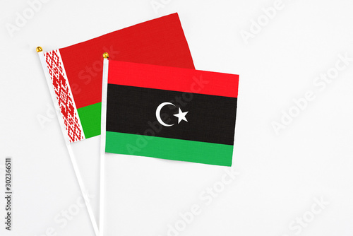 Libya and Belarus stick flags on white background. High quality fabric, miniature national flag. Peaceful global concept.White floor for copy space. photo