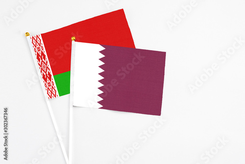 Qatar and Belarus stick flags on white background. High quality fabric, miniature national flag. Peaceful global concept.White floor for copy space.