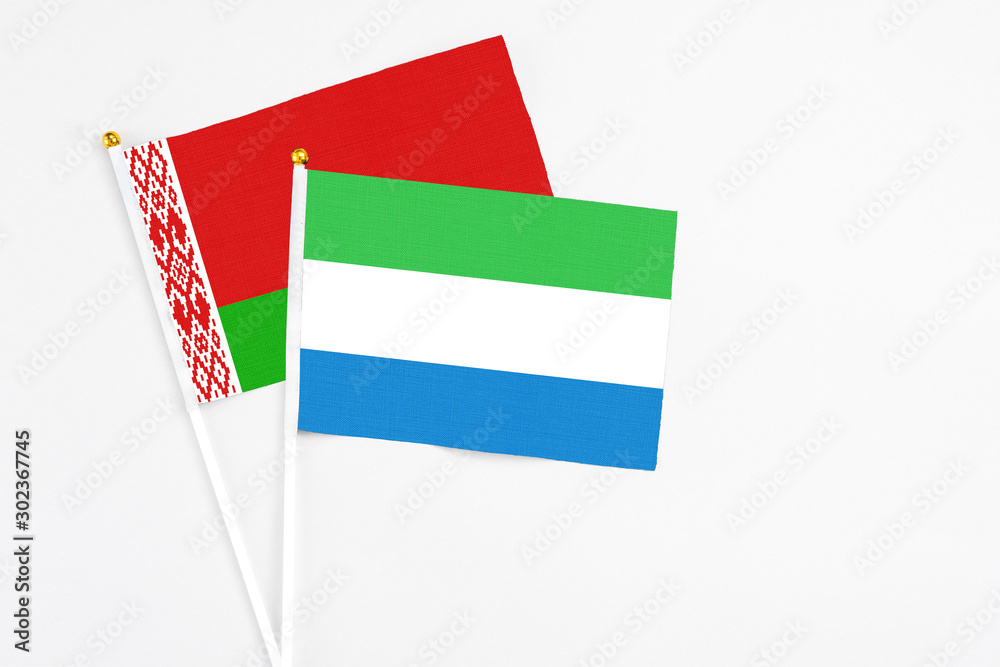Sierra Leone and Belarus stick flags on white background. High quality fabric, miniature national flag. Peaceful global concept.White floor for copy space. Sierra Leone and Belarus stick flags on white background. High quality fabric, miniature national flag. Peaceful global concept.White floor for copy space.