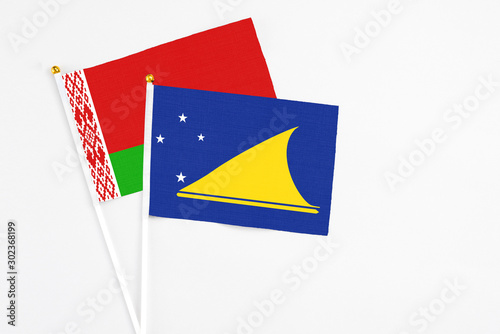 Tokelau and Belarus stick flags on white background. High quality fabric, miniature national flag. Peaceful global concept.White floor for copy space. photo