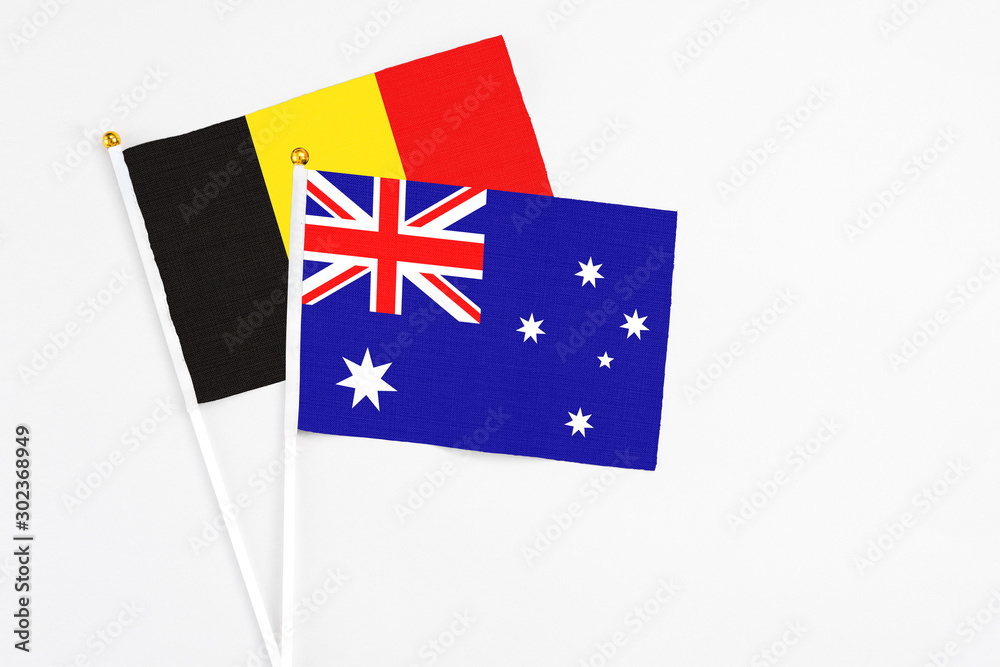 Fototapeta premium Australia and Belgium stick flags on white background. High quality fabric, miniature national flag. Peaceful global concept.White floor for copy space.