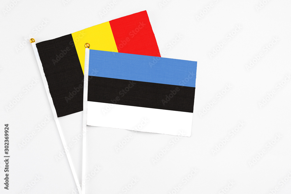 Estonia and Belgium stick flags on white background. High quality fabric, miniature national flag. Peaceful global concept.White floor for copy space.