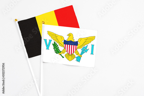 United States Virgin Islands and Belgium stick flags on white background. High quality fabric, miniature national flag. Peaceful global concept.White floor for copy space.