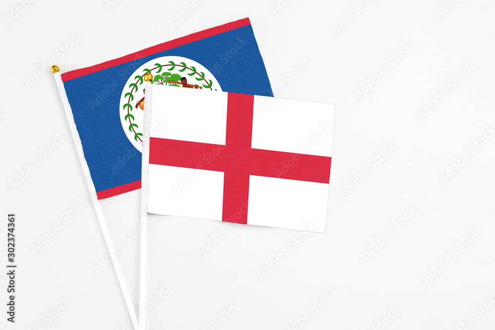 England and Belize stick flags on white background. High quality fabric, miniature national flag. Peaceful global concept.White floor for copy space.