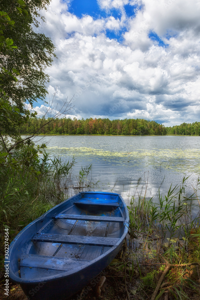 Beautiful view of lake and blue boat in summer Beautiful view of lake and blue boat in summer