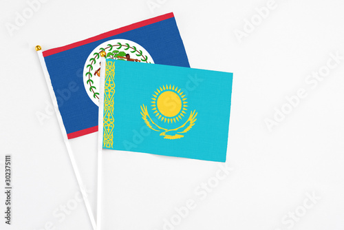 Kazakhstan and Belize stick flags on white background. High quality fabric, miniature national flag. Peaceful global concept.White floor for copy space.