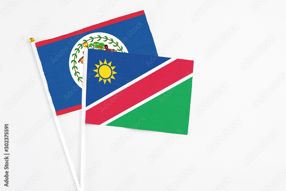 Namibia and Belize stick flags on white background. High quality fabric, miniature national flag. Peaceful global concept.White floor for copy space. Namibia and Belize stick flags on white background. High quality fabric, miniature national flag. Peaceful global concept.White floor for copy space.