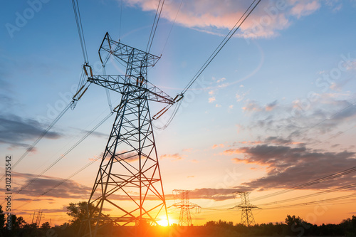 High-voltage power lines at sunset or sunrise. High voltage electric transmission tower