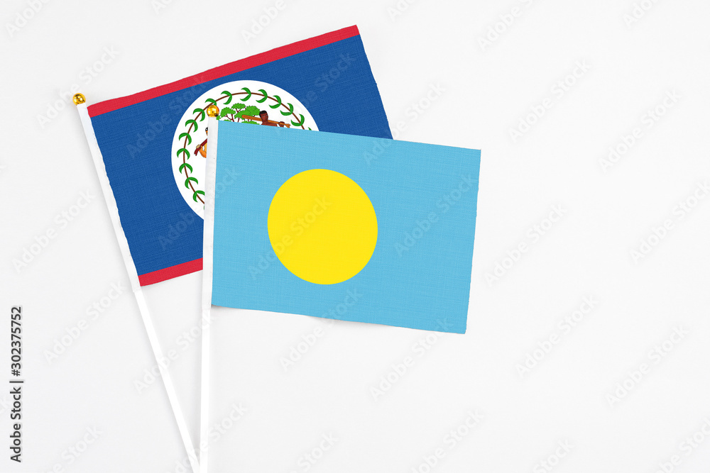 Palau and Belize stick flags on white background. High quality fabric, miniature national flag. Peaceful global concept.White floor for copy space. Palau and Belize stick flags on white background. High quality fabric, miniature national flag. Peaceful global concept.White floor for copy space.