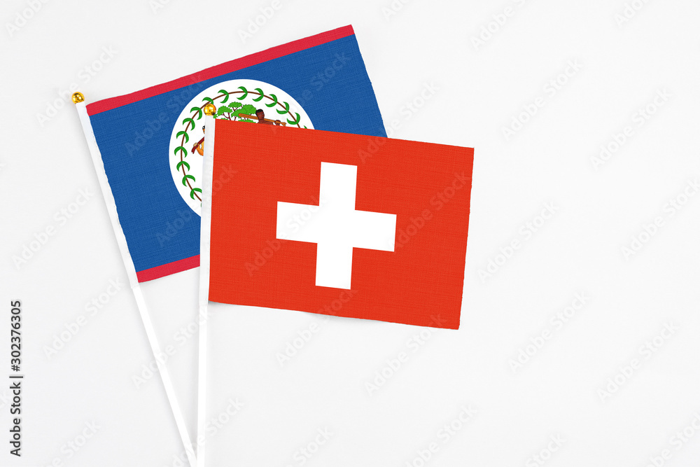 Switzerland and Belize stick flags on white background. High quality fabric, miniature national flag. Peaceful global concept.White floor for copy space.
