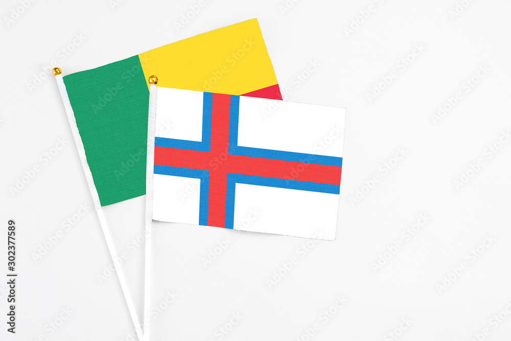 Faroe Islands and Benin stick flags on white background. High quality fabric, miniature national flag. Peaceful global concept.White floor for copy space. Faroe Islands and Benin stick flags on white background. High quality fabric, miniature national flag. Peaceful global concept.White floor for copy space.