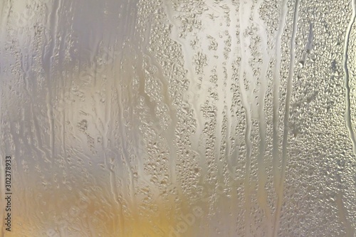 In selective focus many droplets on a restroom mirror with day light for background backdrop