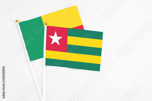 Togo and Benin stick flags on white background. High quality fabric  miniature national flag. Peaceful global concept.White floor for copy space.