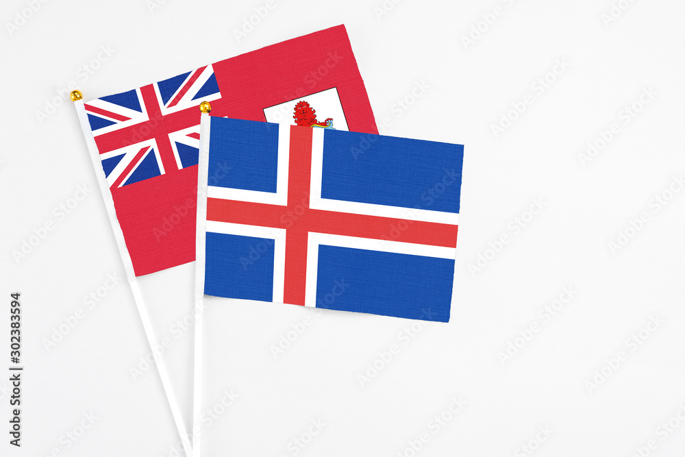 Fototapeta premium Iceland and Bermuda stick flags on white background. High quality fabric, miniature national flag. Peaceful global concept.White floor for copy space.
