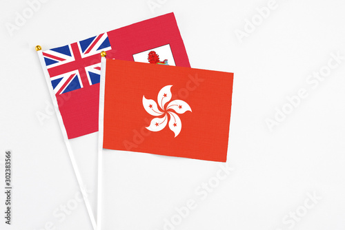 Hong Kong and Bermuda stick flags on white background. High quality fabric, miniature national flag. Peaceful global concept.White floor for copy space.