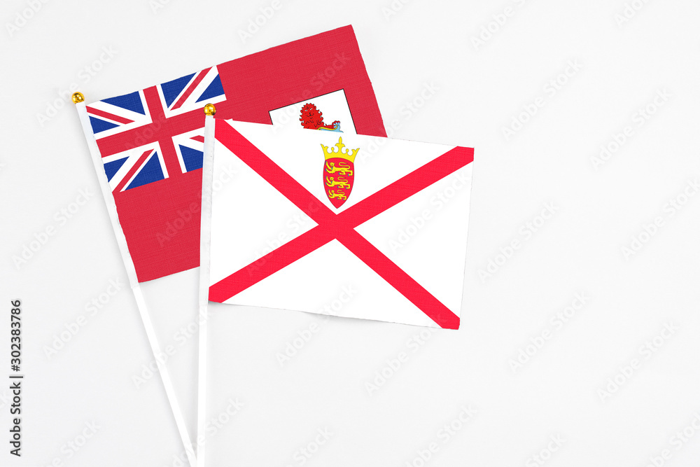 Jersey and Bermuda stick flags on white background. High quality fabric, miniature national flag. Peaceful global concept.White floor for copy space.