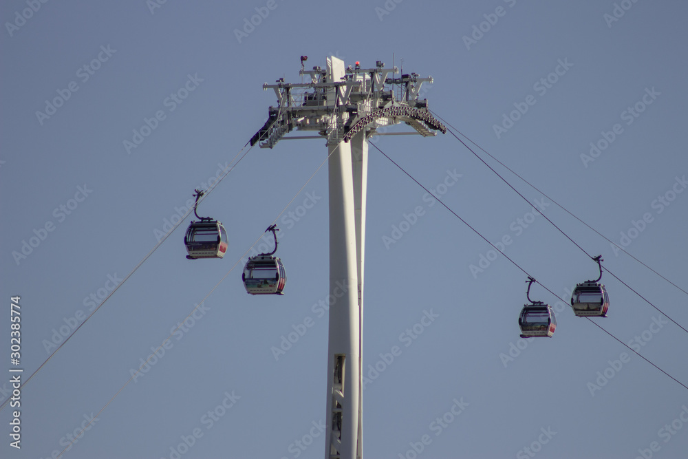 Tall ski cableway in mountains, big cabin gondola lift pillar running on wires ropeway