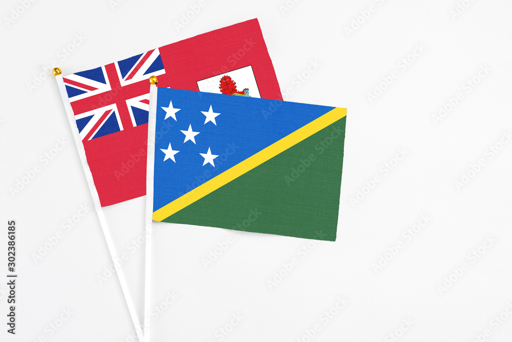 Solomon Islands and Bermuda stick flags on white background. High quality fabric, miniature national flag. Peaceful global concept.White floor for copy space. Solomon Islands and Bermuda stick flags on white background. High quality fabric, miniature national flag. Peaceful global concept.White floor for copy space.