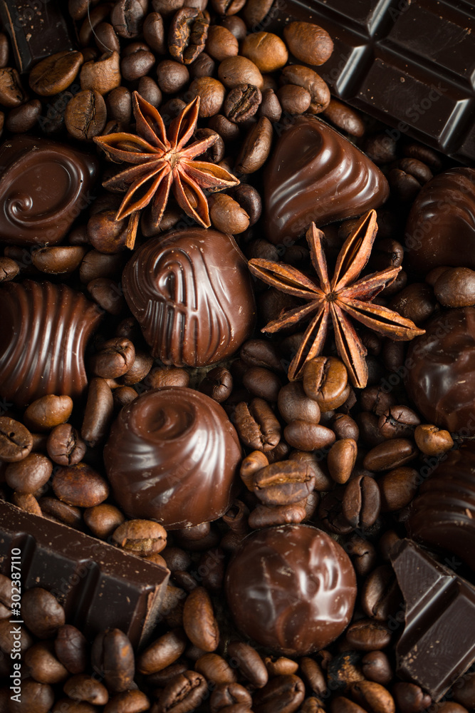 Assortment of white, dark, and milk chocolate. Chocolate with cream, nuts, almonds, hazelnuts and cinnamon with coffee beans. Sweet food and no diet concept.