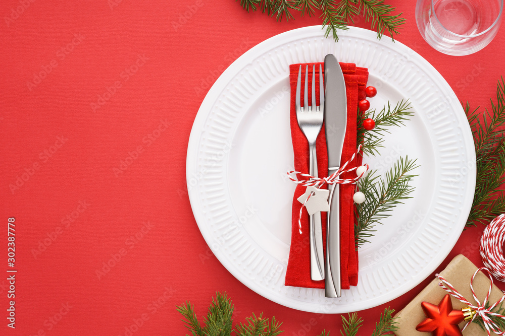 Christmas table setting with white plates, napkin and cutlery. Christmas table setting with white plates, napkin and cutlery.