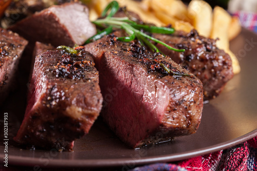 Slices of beef steak served with baked artichoke