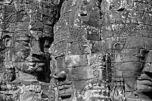 Black and white picture of Ancient stone faces of Bayon temple in complex Angkor Wat in Siem Reap, Cambodia 