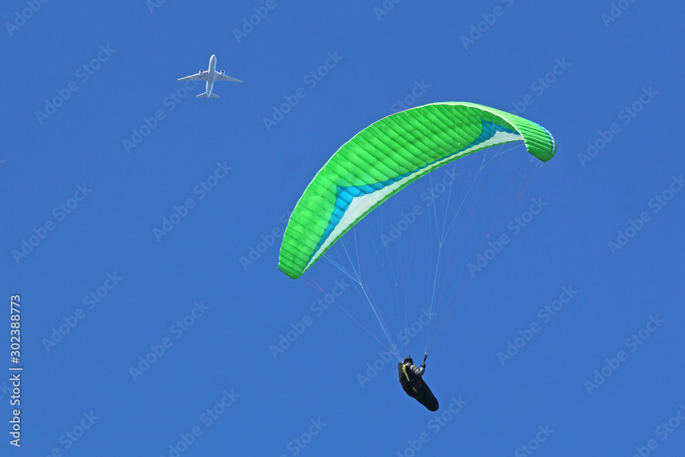 Paraglider flying wing in a blue sky Paraglider flying wing in a blue sky