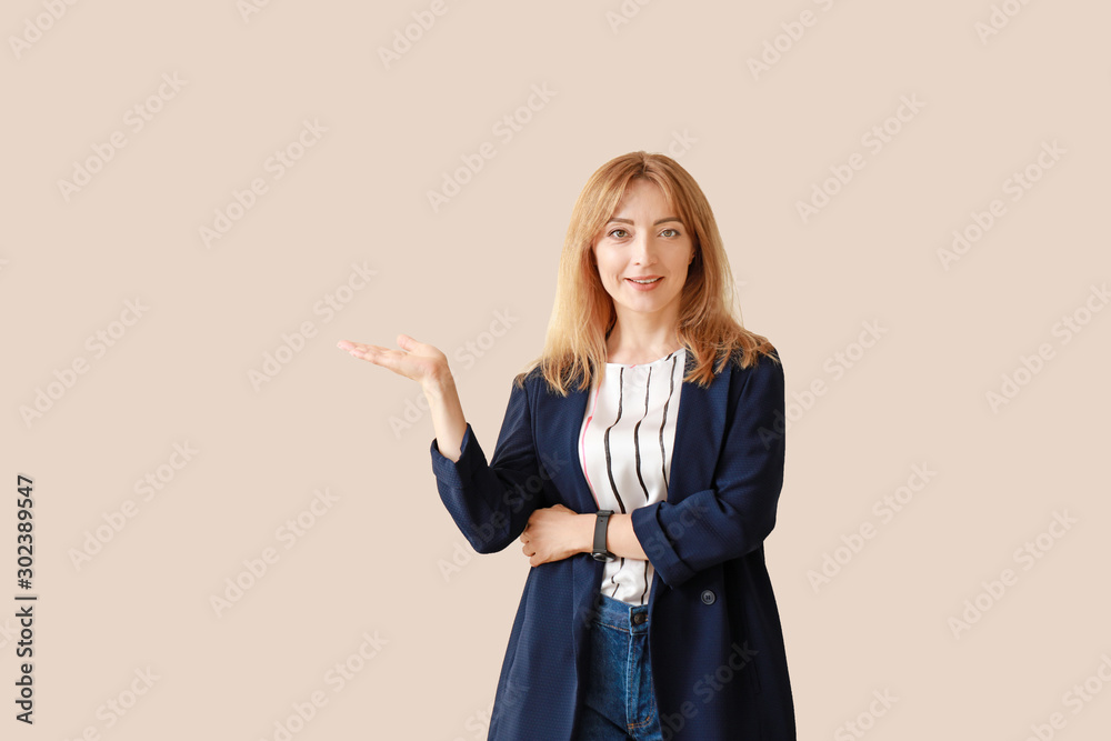 Portrait of stylish mature businesswoman showing something on light background Portrait of stylish mature businesswoman showing something on light background