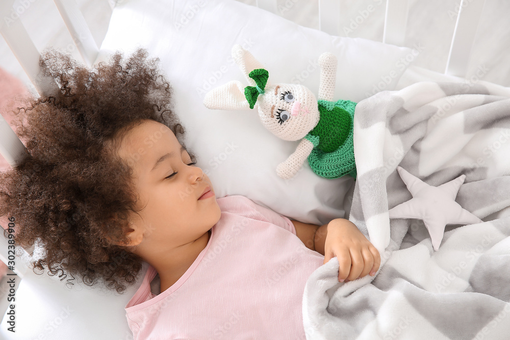 Little African-American girl sleeping in bed - obrazy, fototapety, plakaty 
