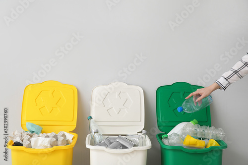 Woman throwing garbage into container. Recycling concept photo