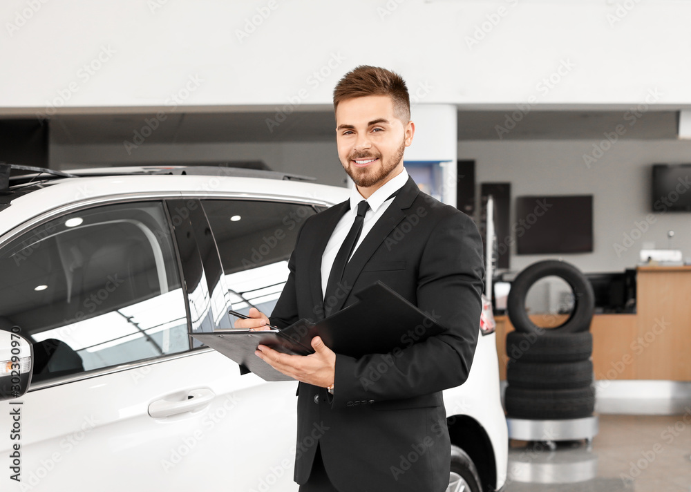 Salesman near car in modern salon Salesman near car in modern salon