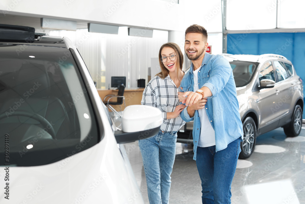 Couple buying new car in salon Couple buying new car in salon