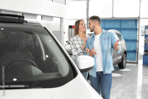 Couple buying new car in salon