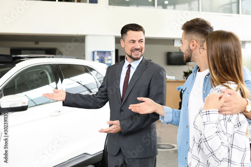 Couple buying new car in salon