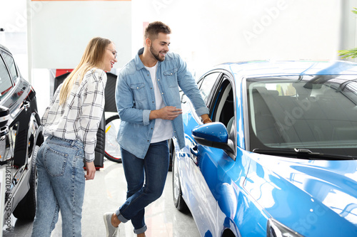 Couple buying new car in salon