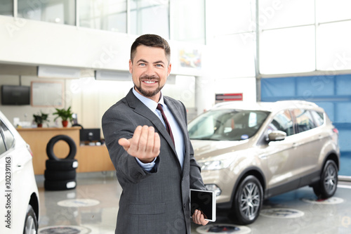 Salesman in modern car salon