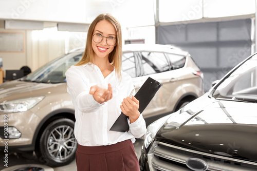 Saleswoman near car in mode...