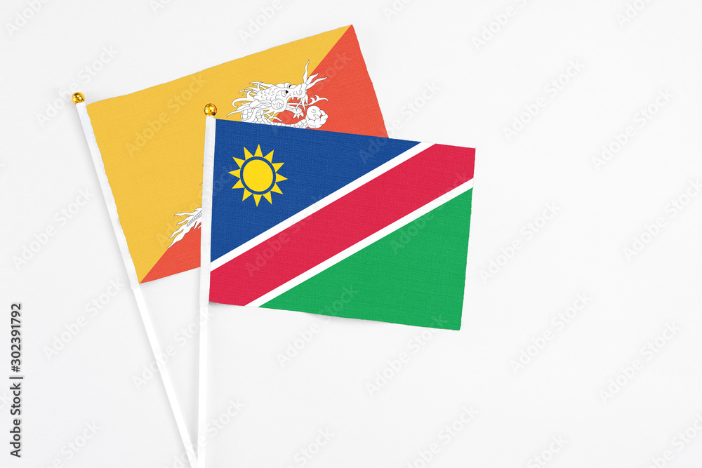 Namibia and Bhutan stick flags on white background. High quality fabric, miniature national flag. Peaceful global concept.White floor for copy space. Namibia and Bhutan stick flags on white background. High quality fabric, miniature national flag. Peaceful global concept.White floor for copy space.