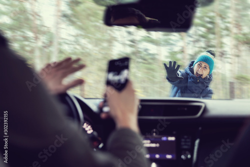 pedestrian accident - man using a phone while driving a car photo