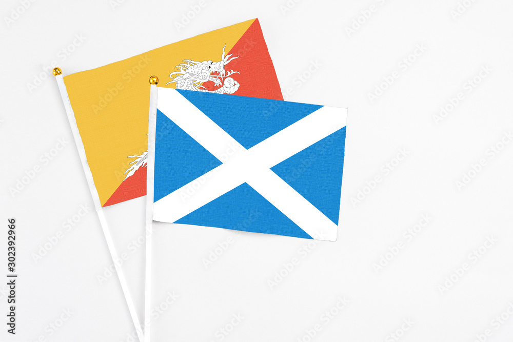 Scotland and Bhutan stick flags on white background. High quality fabric, miniature national flag. Peaceful global concept.White floor for copy space. Scotland and Bhutan stick flags on white background. High quality fabric, miniature national flag. Peaceful global concept.White floor for copy space.