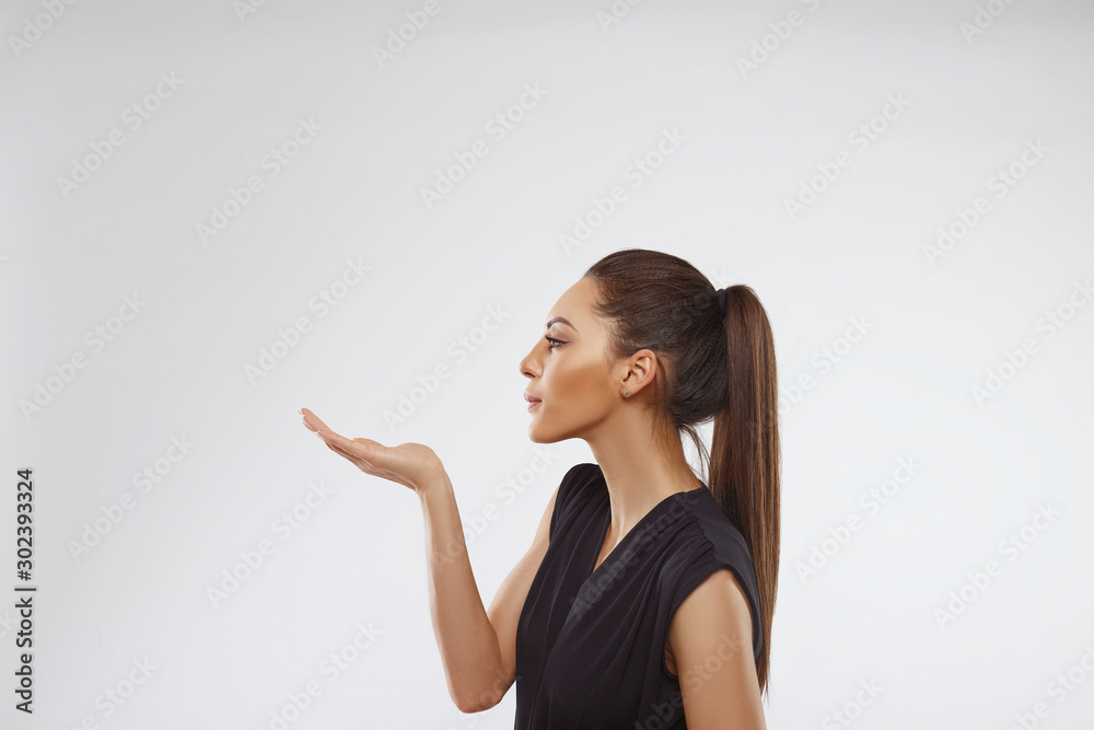 Woman holding something on the palms..Portrait of a happy smiling woman holding copyspace on the palm isolated on a white background. Proposing a product. Gesture for advertisement. Woman holding something on the palms..Portrait of a happy smiling woman holding copyspace on the palm isolated on a white background. Proposing a product. Gesture for advertisement.