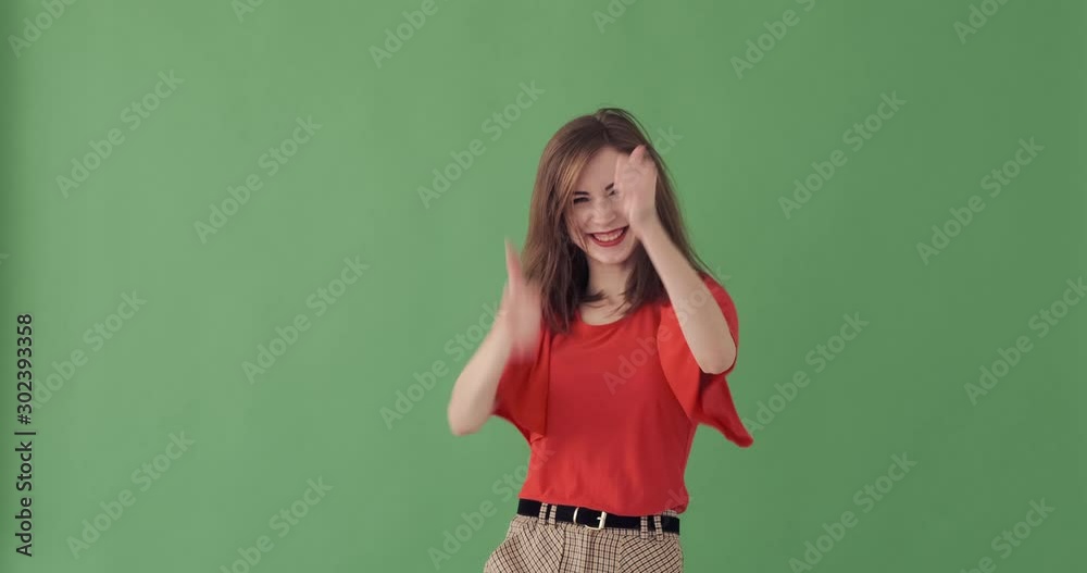 Crazy young woman giving thumbs up gesture and celebrating success over green background Crazy young woman giving thumbs up gesture and celebrating success over green background