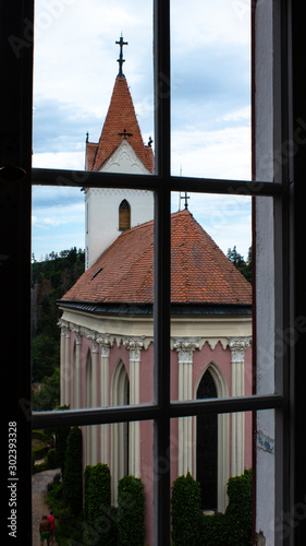 Old Christian pink church behind a window on a castle. photo