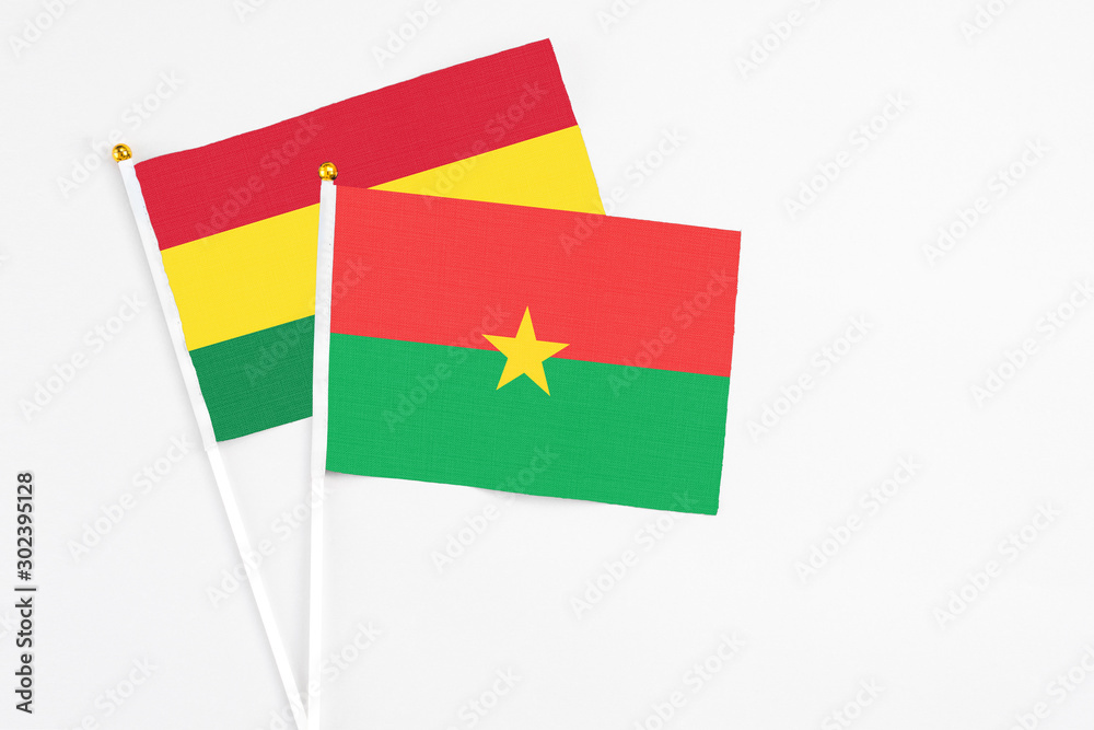 Burkina Faso and Bolivia stick flags on white background. High quality fabric, miniature national flag. Peaceful global concept.White floor for copy space. Burkina Faso and Bolivia stick flags on white background. High quality fabric, miniature national flag. Peaceful global concept.White floor for copy space.