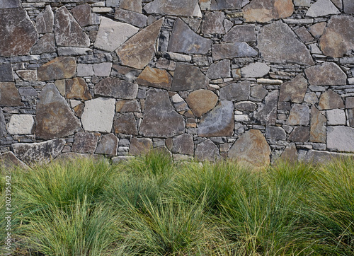 Grassy landscape garden against stone wall photo