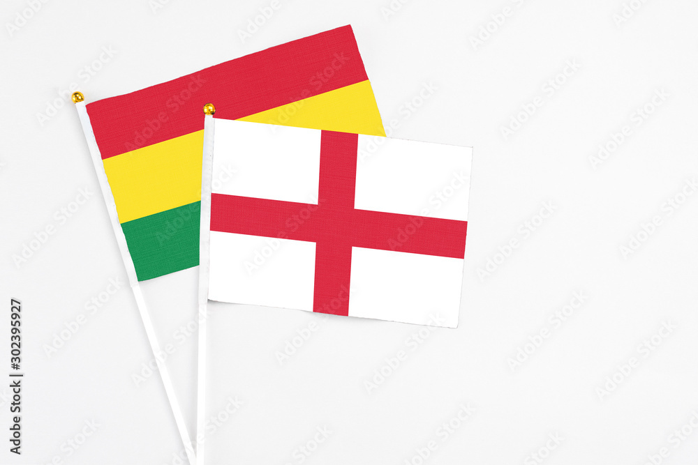 England and Bolivia stick flags on white background. High quality fabric, miniature national flag. Peaceful global concept.White floor for copy space.