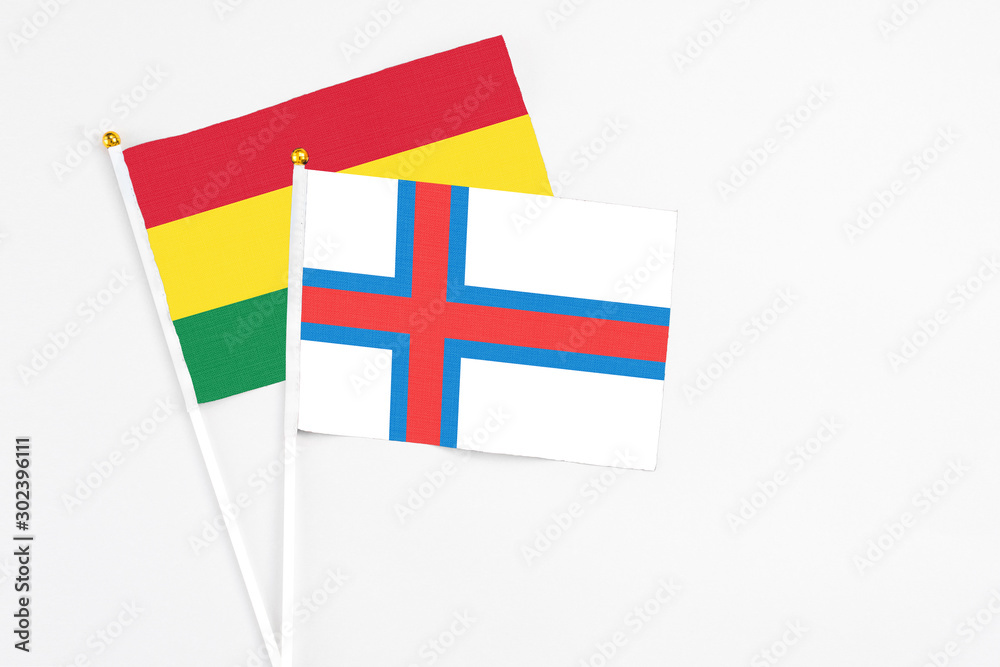 Faroe Islands and Bolivia stick flags on white background. High quality fabric, miniature national flag. Peaceful global concept.White floor for copy space.