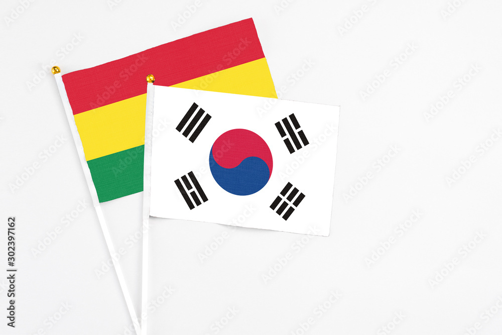 South Korea and Bolivia stick flags on white background. High quality fabric, miniature national flag. Peaceful global concept.White floor for copy space. South Korea and Bolivia stick flags on white background. High quality fabric, miniature national flag. Peaceful global concept.White floor for copy space.