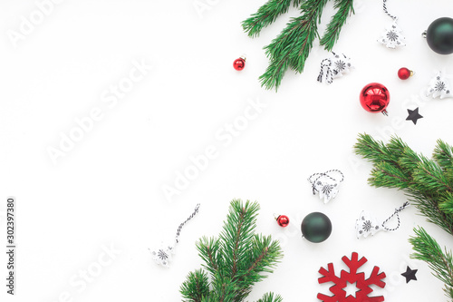 Red and green Christmas decorations on white background, flat lay, top view