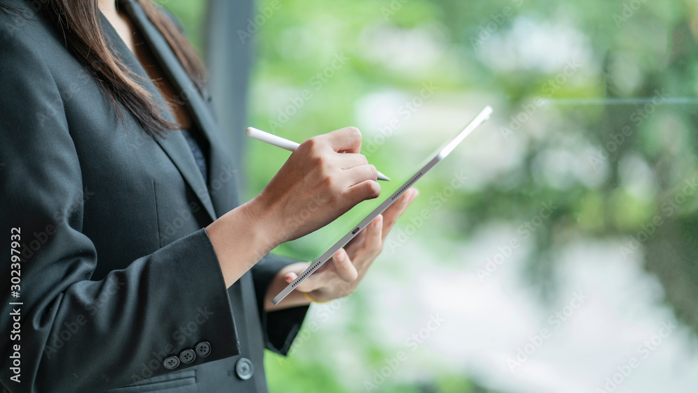 cropped view of businesswoman in suit using digital tablet.